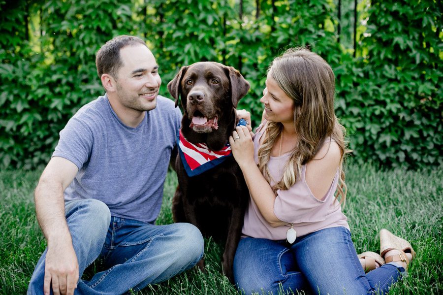 engaged couple playing with dog at scioto mile