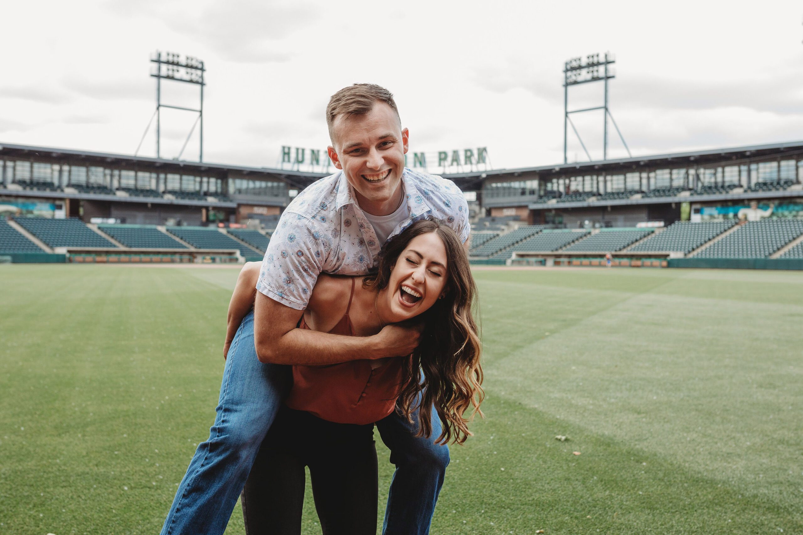bride giving piggy back ride to fiancé in Columbus Ohio at Huntington park