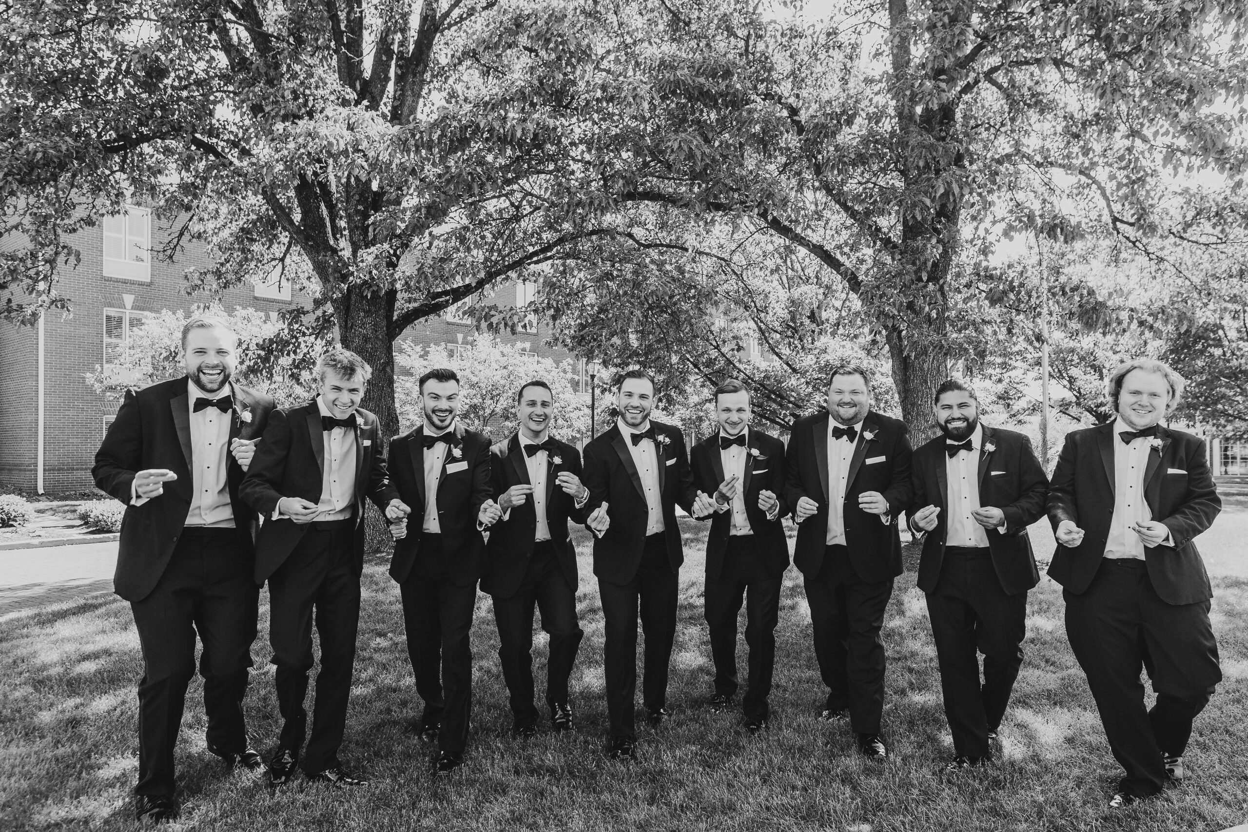 black and white photo of groom and groomsmen snapping fingers at Nationwide Hotel and Conference Center