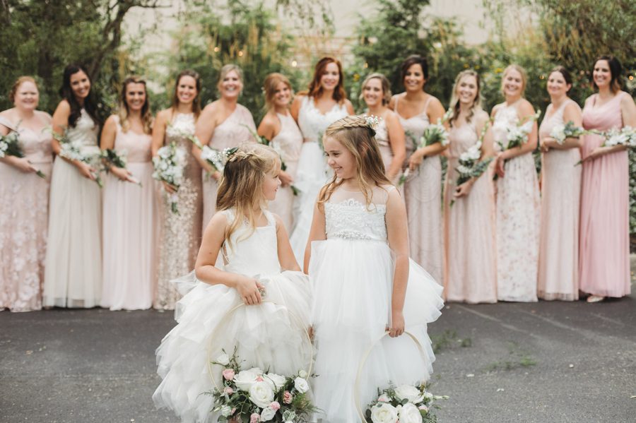 cute flower girls in front of bridesmaids