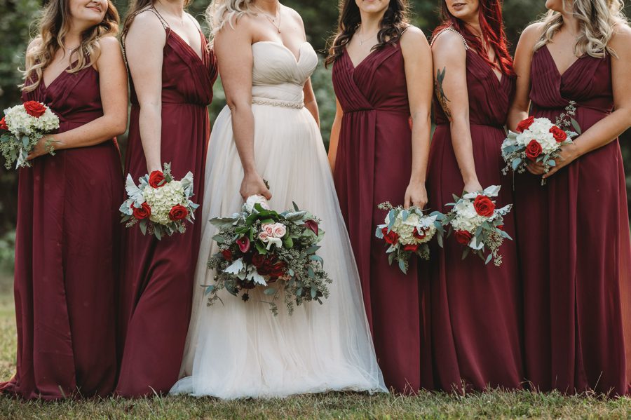 bride and bridesmaids bouquets with red and blush roses and lambs ear