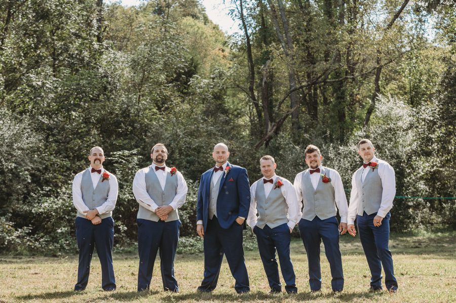 groom with groomsmen in grey vests and navy pants