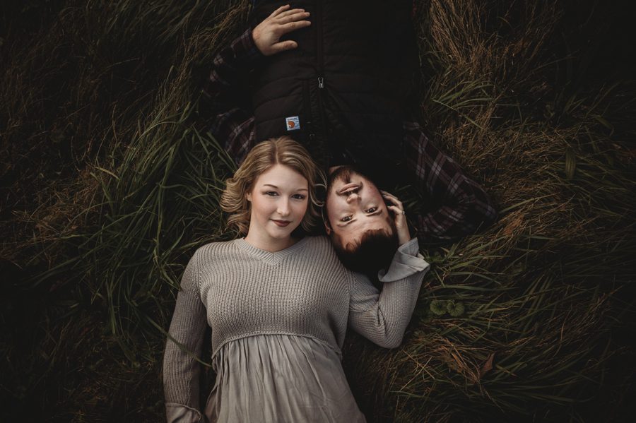 engaged couple laying in tall grass at Camping Engagement Photos in Mount Vernon Ohio
