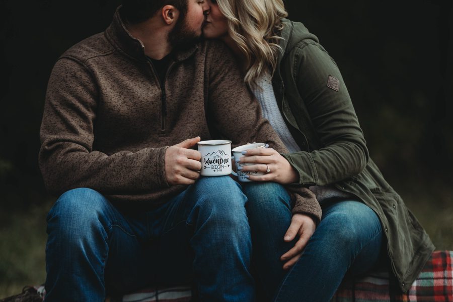 close up photo of engaged couple holding mugs of hot chocolate