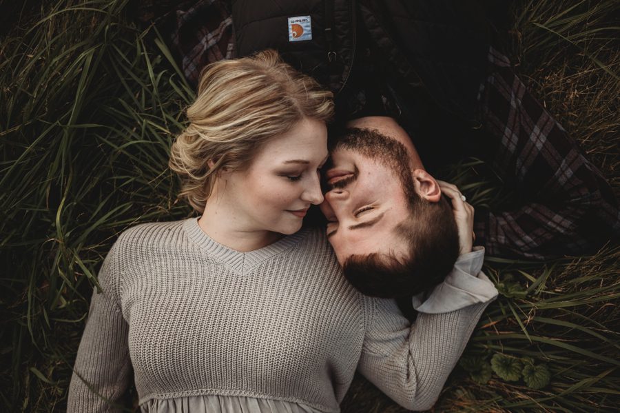 engaged couple snuggled in grass at Camping Engagement Photos in Mount Vernon Ohio