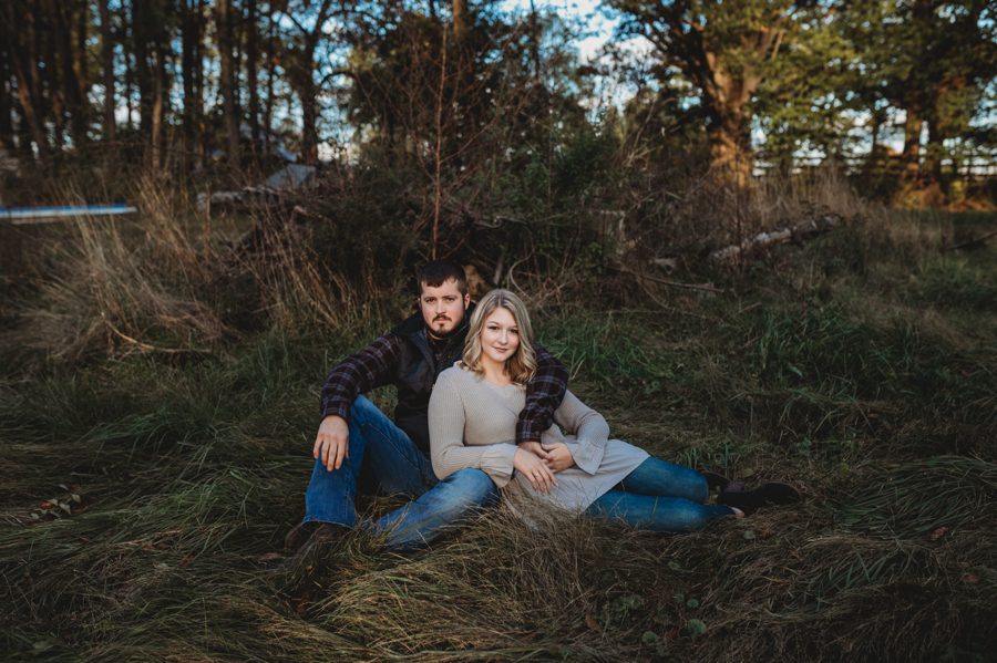 engaged couple laying in grass at farm for Camping Engagement Photos in Mount Vernon Ohio 