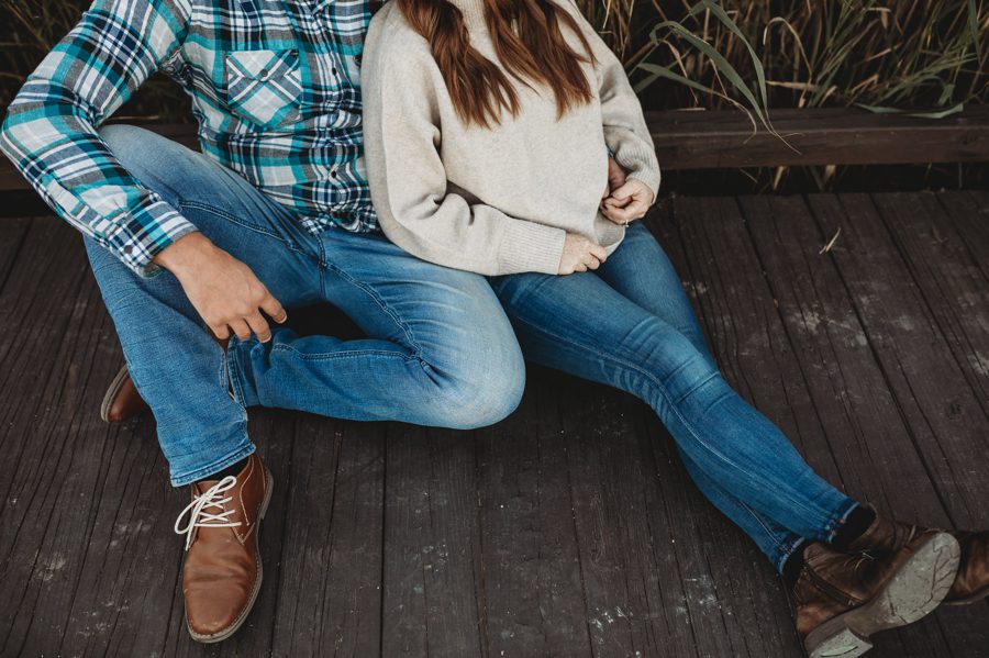 image of engaged couple's legs while sitting on dock
