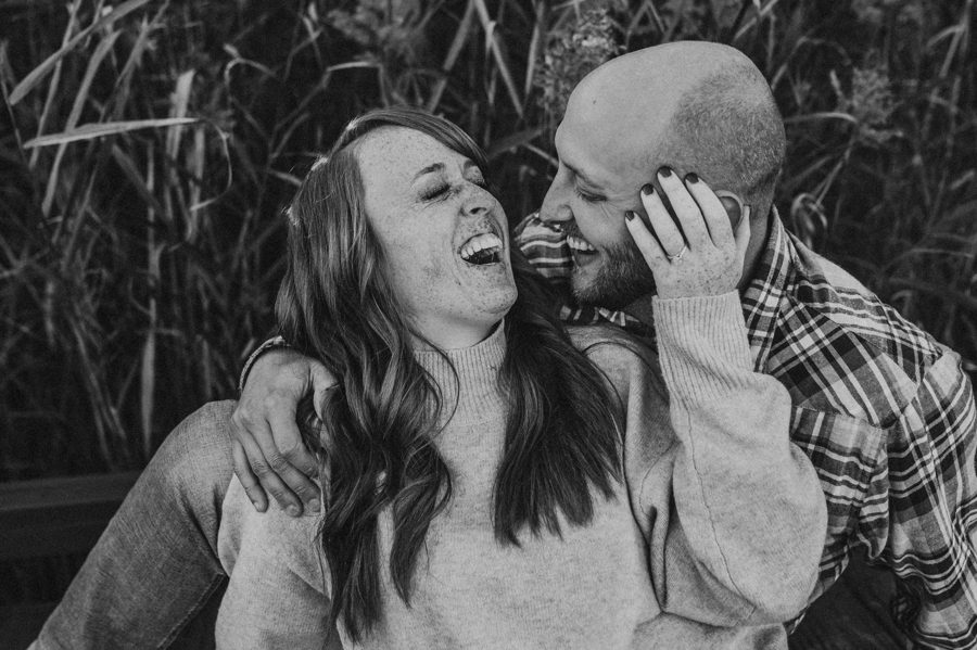 black and white image of engaged couple laughing out loud