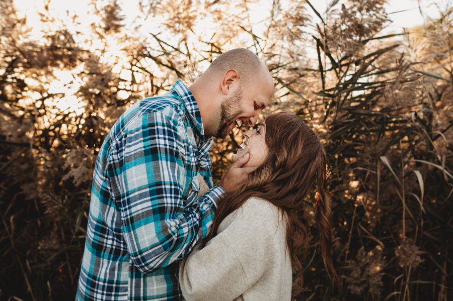 engaged couple laughing with ornamental grasses behind them