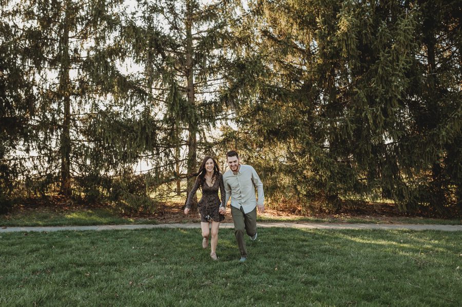 engaged couple holding hands and running at Homestead Park Engagement