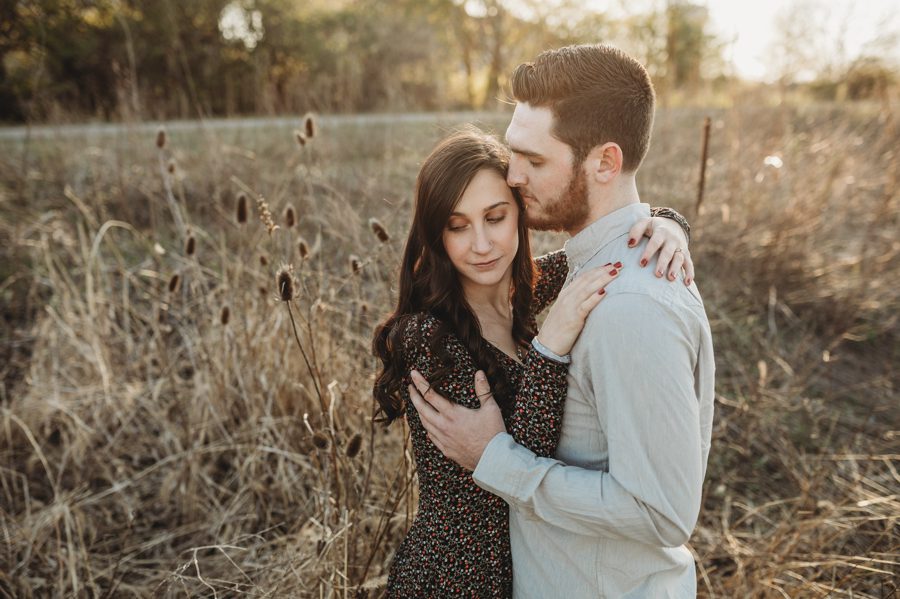 man snuggled with fiancé in a field at Homestead Park Engagement