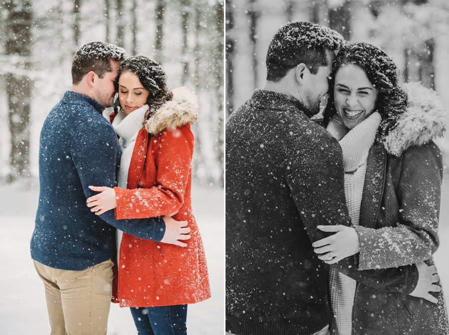 black and white image of man whispering in fiancés ear in the snow