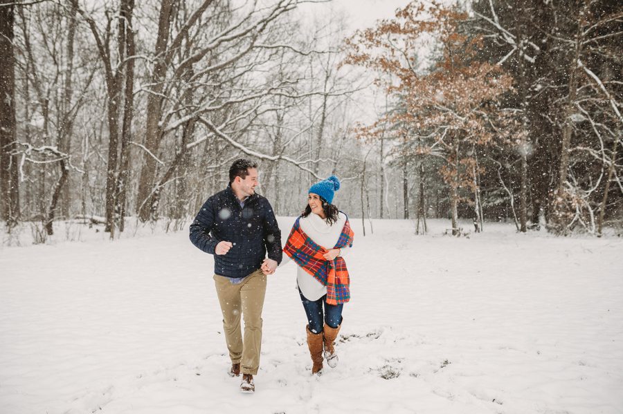 engaged couple racing each other in the snow at Hoover Reservoir Engagement