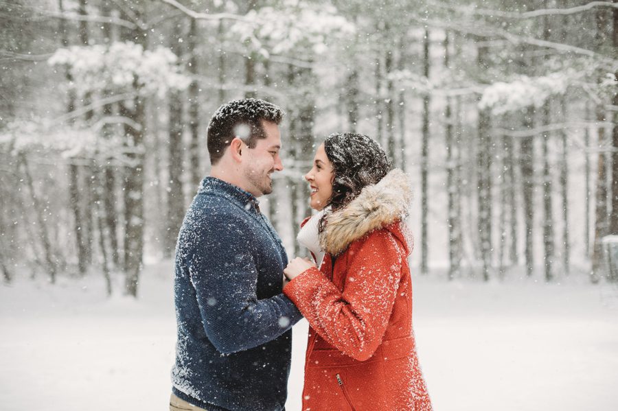 engaged couple in the snow looking at each other while holding hands at Hoover Reservoir Engagement
