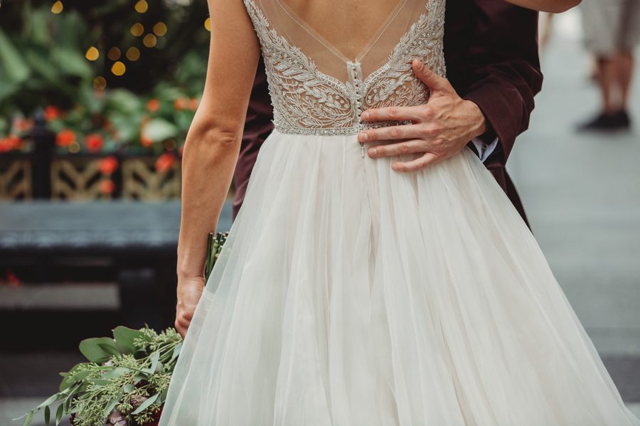 grooms hand on brides lower back