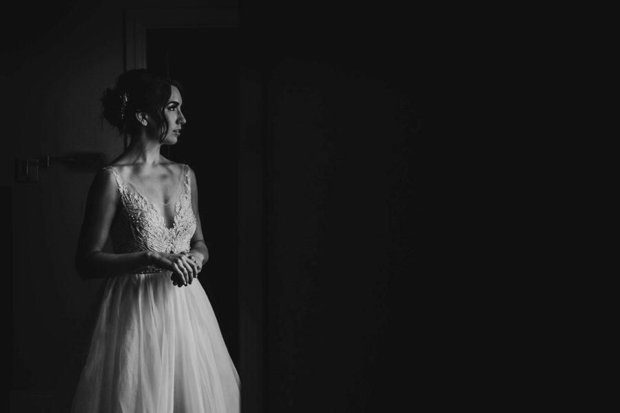 black and white moody photo of bride holding hands together