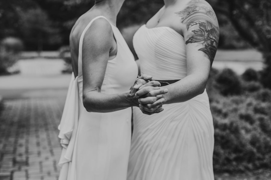 close up black and white photo of holding hands at wedding
