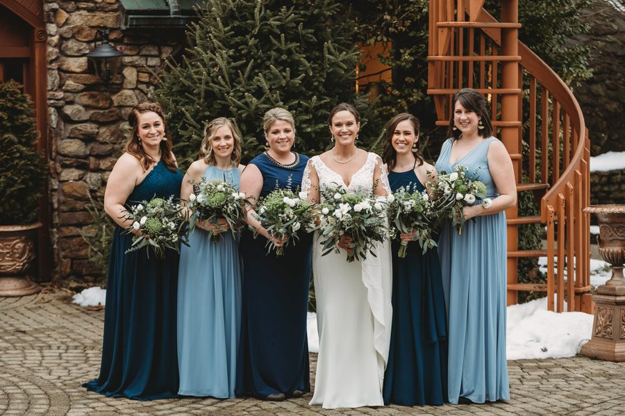 bride with bridesmaids wearing dusty blue and navy blue dresses at Landolls Mohican Castle Wedding