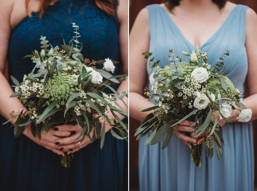 bridesmaids in dusty blue and navy blue dresses holding bouquets