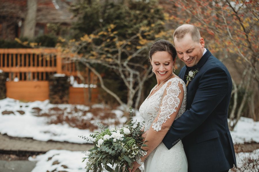 bride and groom snuggled together at winter wedding at mohican castle