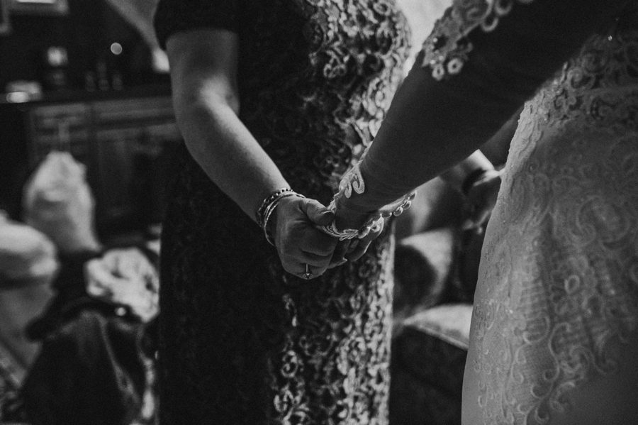 bride and mother of bride holding hands