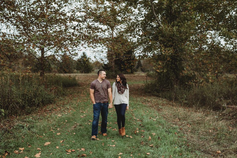 image of engaged couple walking and holding hands at an Ohio park in the fall