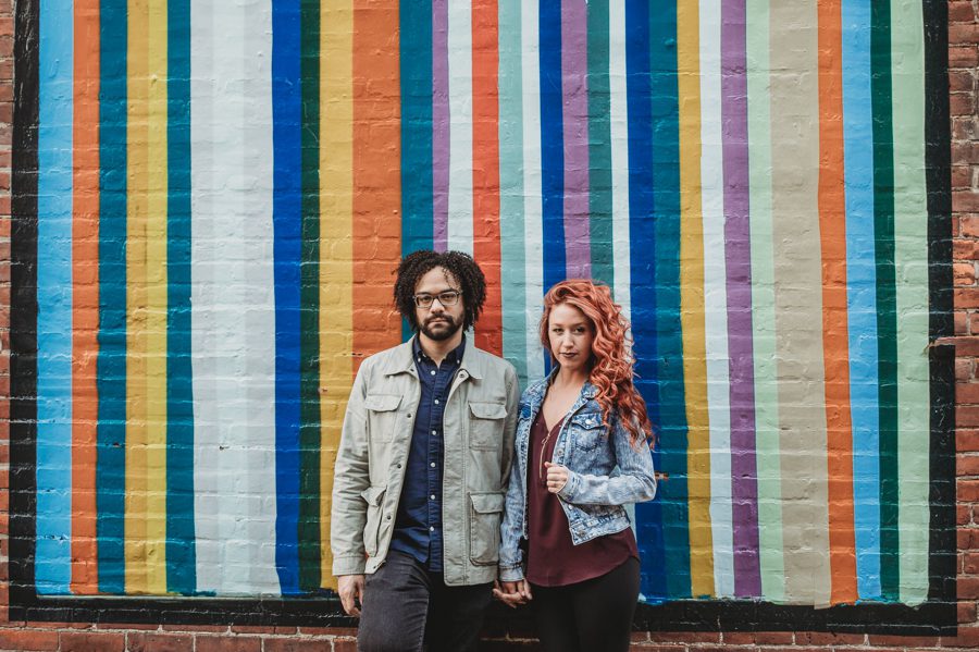engaged couple not smiling in front of striped wall in short north Columbus Ohio