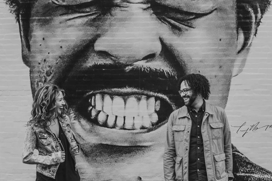 black and white image of engaged couple smiling at each other in front of Richard Pryor mural in Columbus at North 4th Corridor Engagement