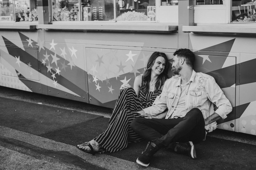 black and white photo of engaged couple sitting on the ground