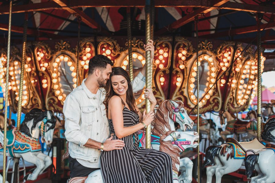 engaged couple on carousel at Ohio state fair engagement