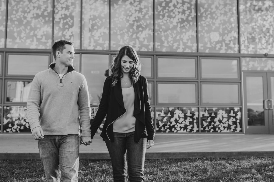 black and white image of couple holding hands and walking