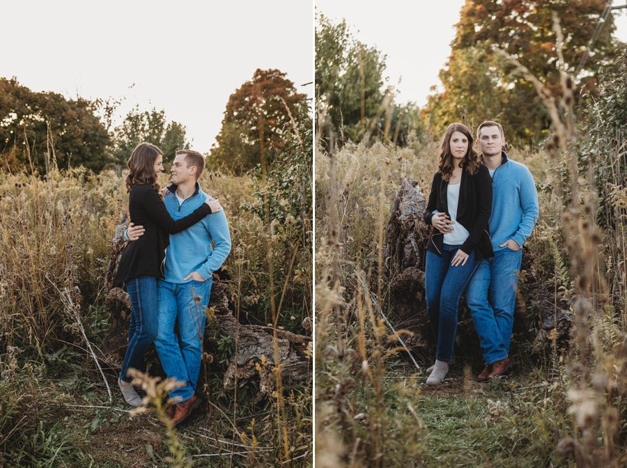 man resting on large log with arm around fiancé