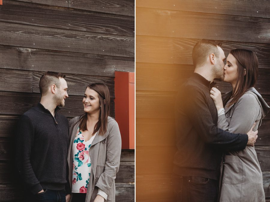 engaged couple kissing with wood brown wall behind them at Scioto Audubon Photos