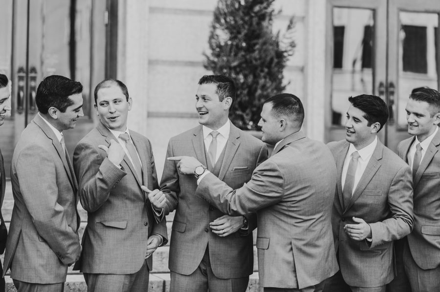 black and white photo of groom and groomsmen laughing
