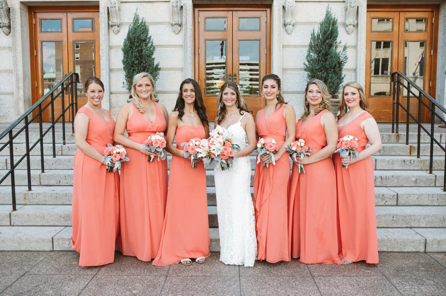bride with bridesmaids in sunset coral dresses at The Ivory Room