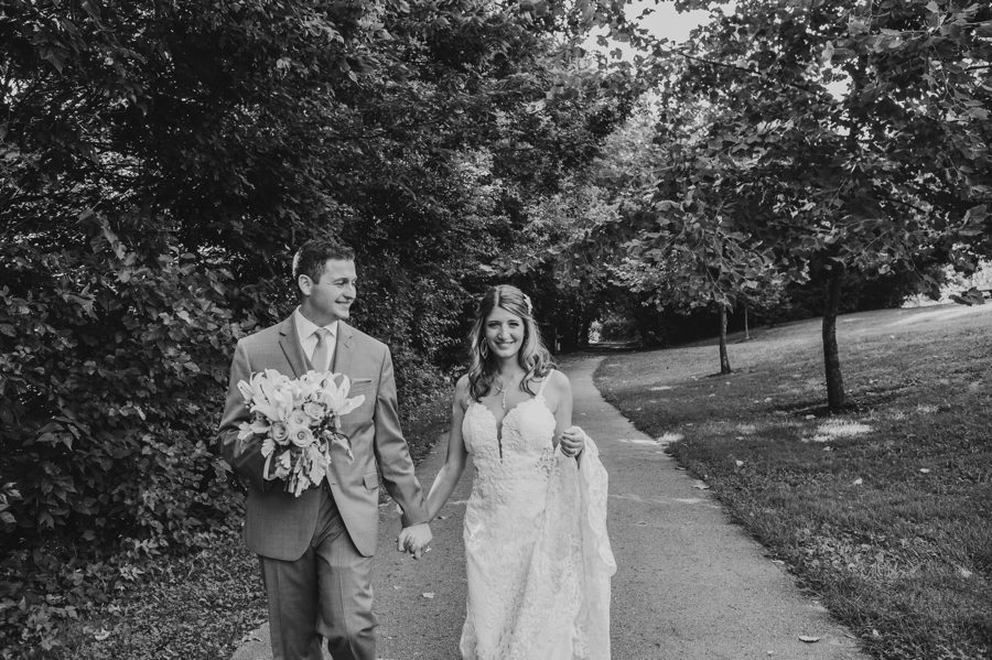 black and white photo of bride smiling and groom looking at her