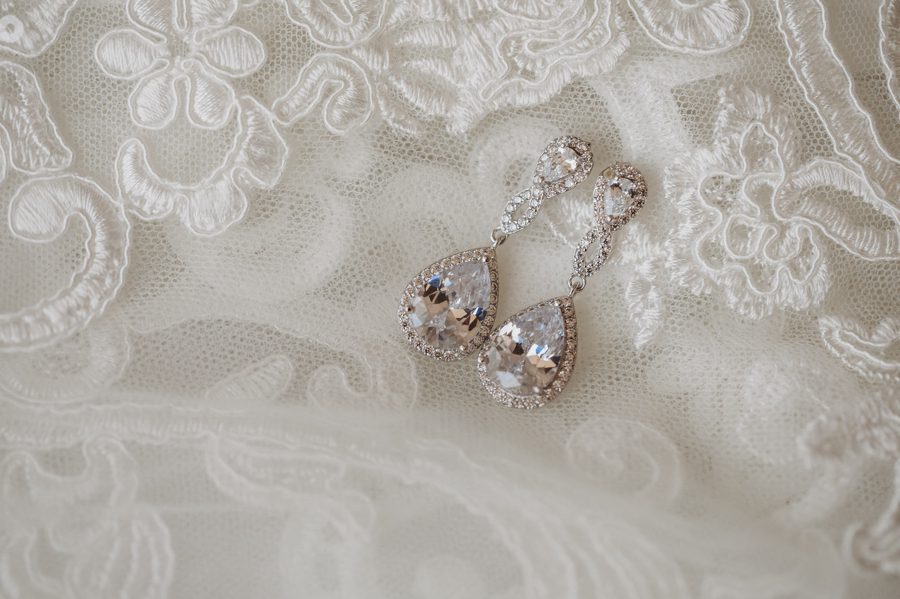 bridal earrings on lace wedding gown