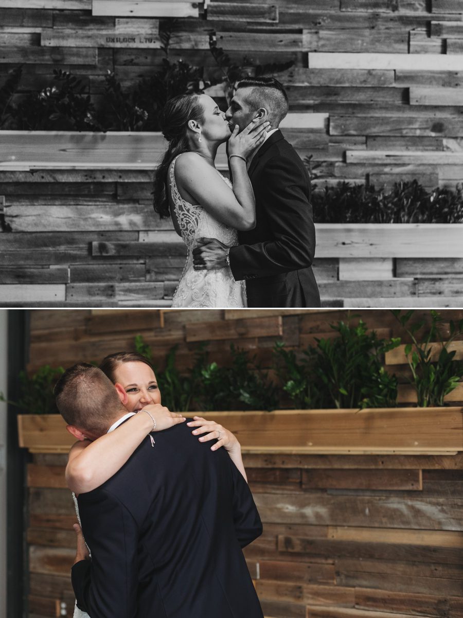 black and white photo of bride and groom kissing in front of wood wall