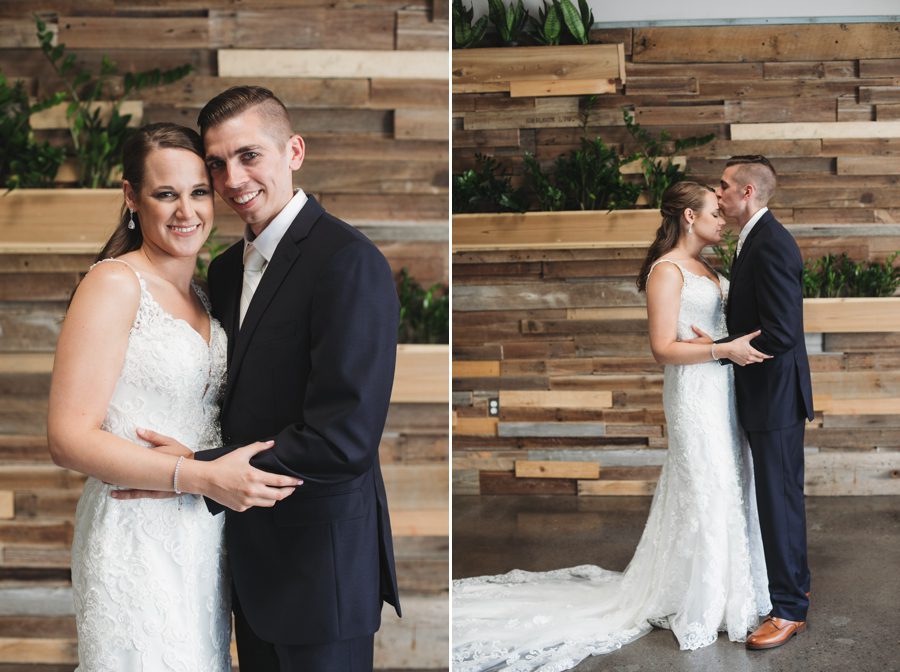bride and groom smiling in front of wood wall