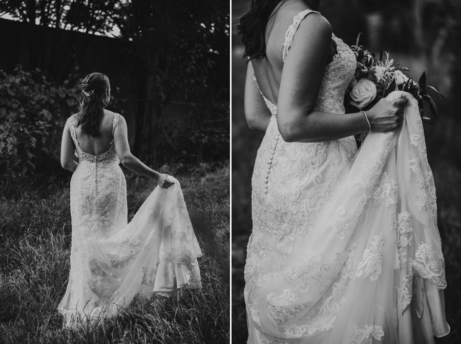 bride holding up dress in grassy field
