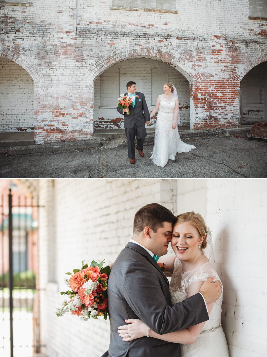 bride and groom walking holding hands in front of what washed brick wall