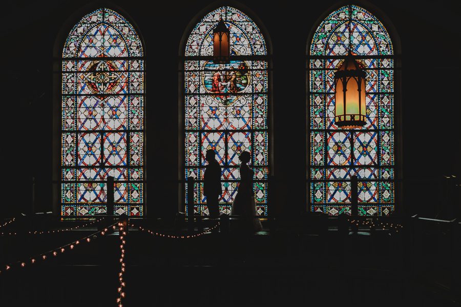 bride and groom silhouette photo in front of stained glass windows at The Bluestone Tiffany Blue Wedding in Columbus Ohio