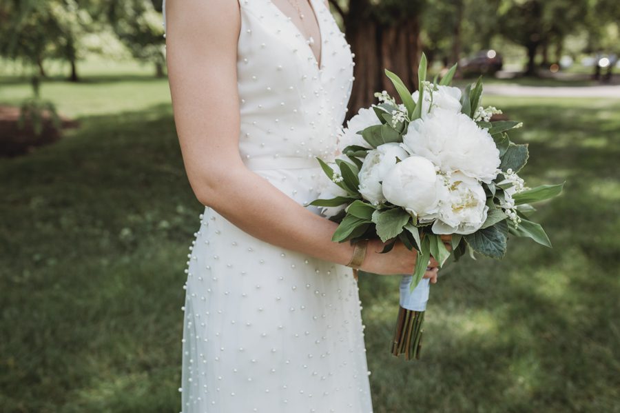 Side view of Kelsey holding her white peony bouquet