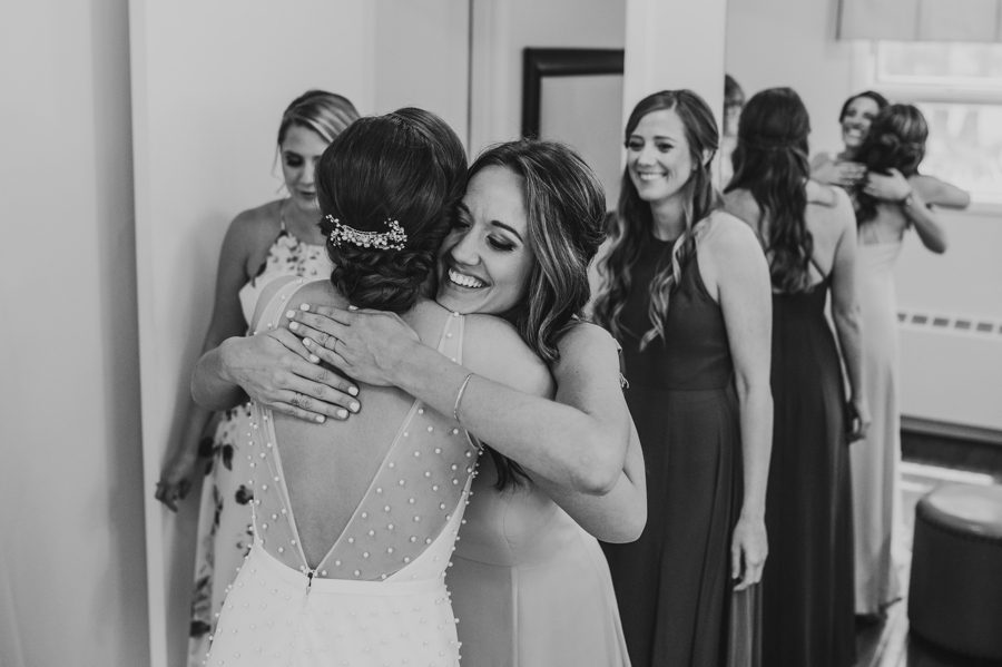 Black and white capture of Kelsey hugging one of her bridesmaids