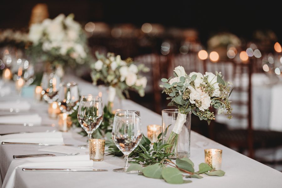 Eucalyptus and white florals and gold candle holders for wedding centerpieces