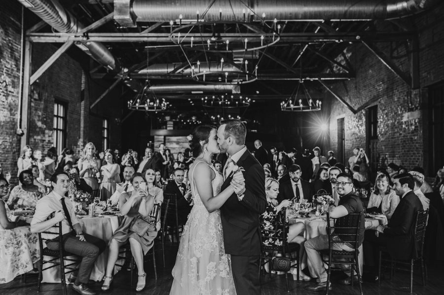 Emilee and Michael kissing at the end of first dance and wedding guests cheering for them