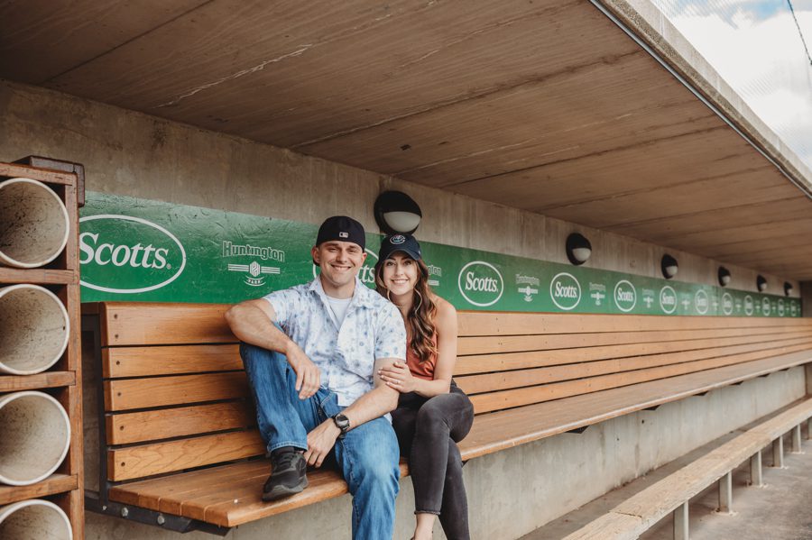 engaged couple sitting in dug out at Huntington Park Engagement Photos