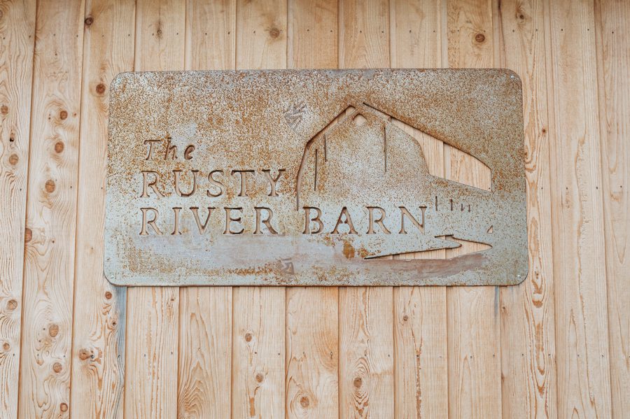 Rusty metal sign on wood barn at the Rusty River Barn