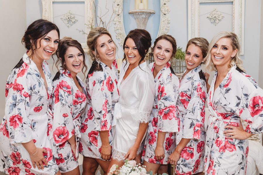 Cortni in a white robe with her bridesmaids in pink floral robes