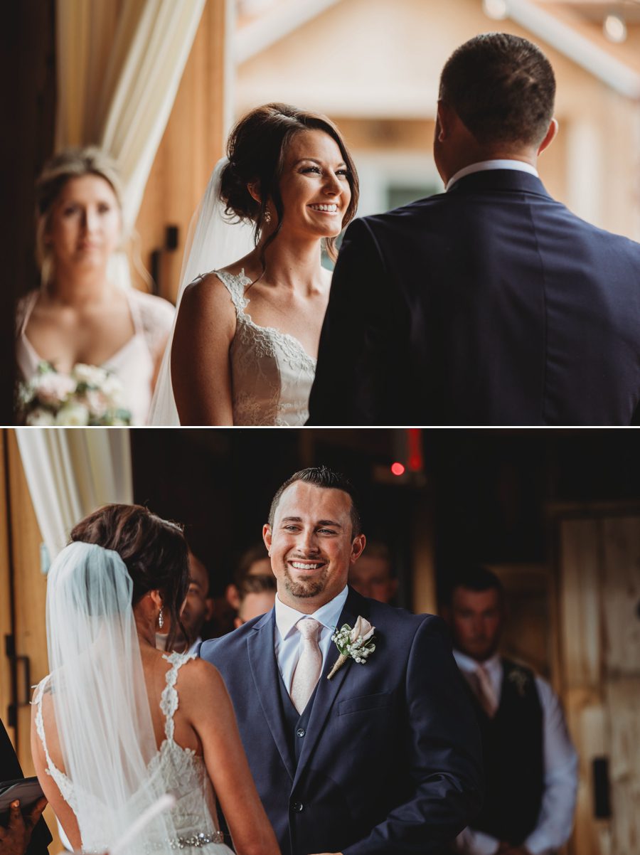 Cortni and Darren smiling at each other during their wedding ceremony at Rusty River Barn